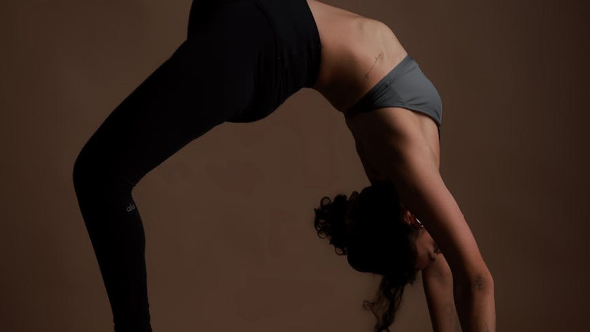 Person practicing yoga in a dark aesthetic studio setup